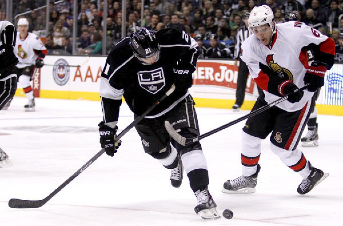 Kings right wing Matt Frattin battles Senators right wing Bobby Ryan for the puck during the first period of a game last week at Staples Center.