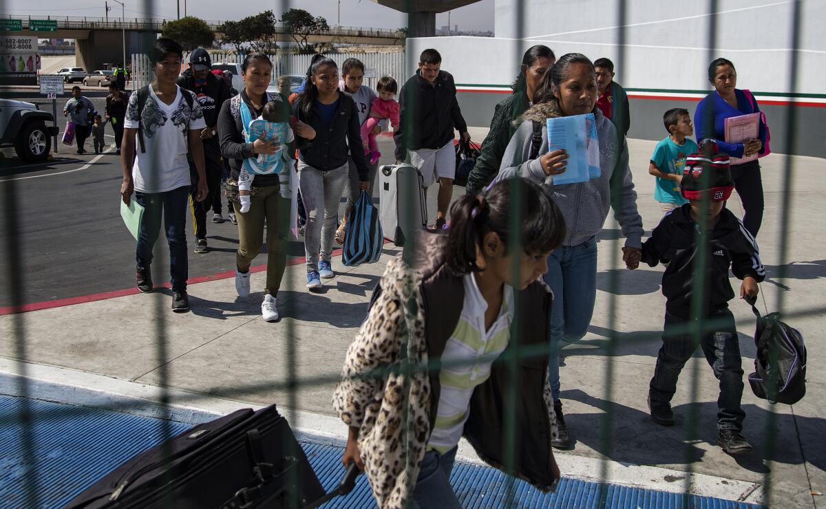 Guatemalan immigrant Dalila Pojoy and her children Bernardethe, Diana and Davis cross the final fence before before seeking asylum in the United States.