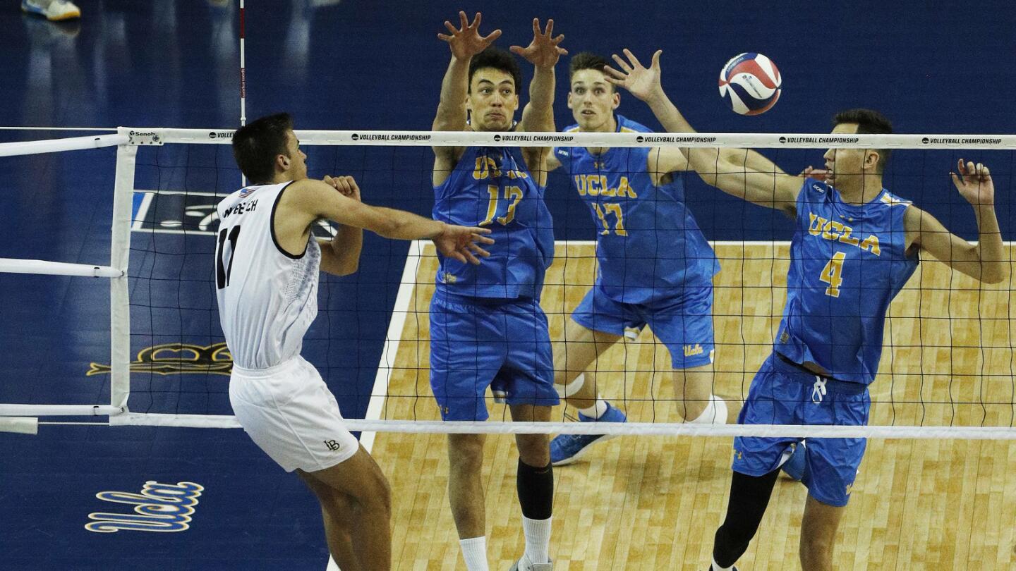 Long Beach State outside hitter TJ DeFalco (11) sends a kill shot through the hands of Micah Ma'a (13), Christian Hessenauer (17) and Oliver Martin (4).