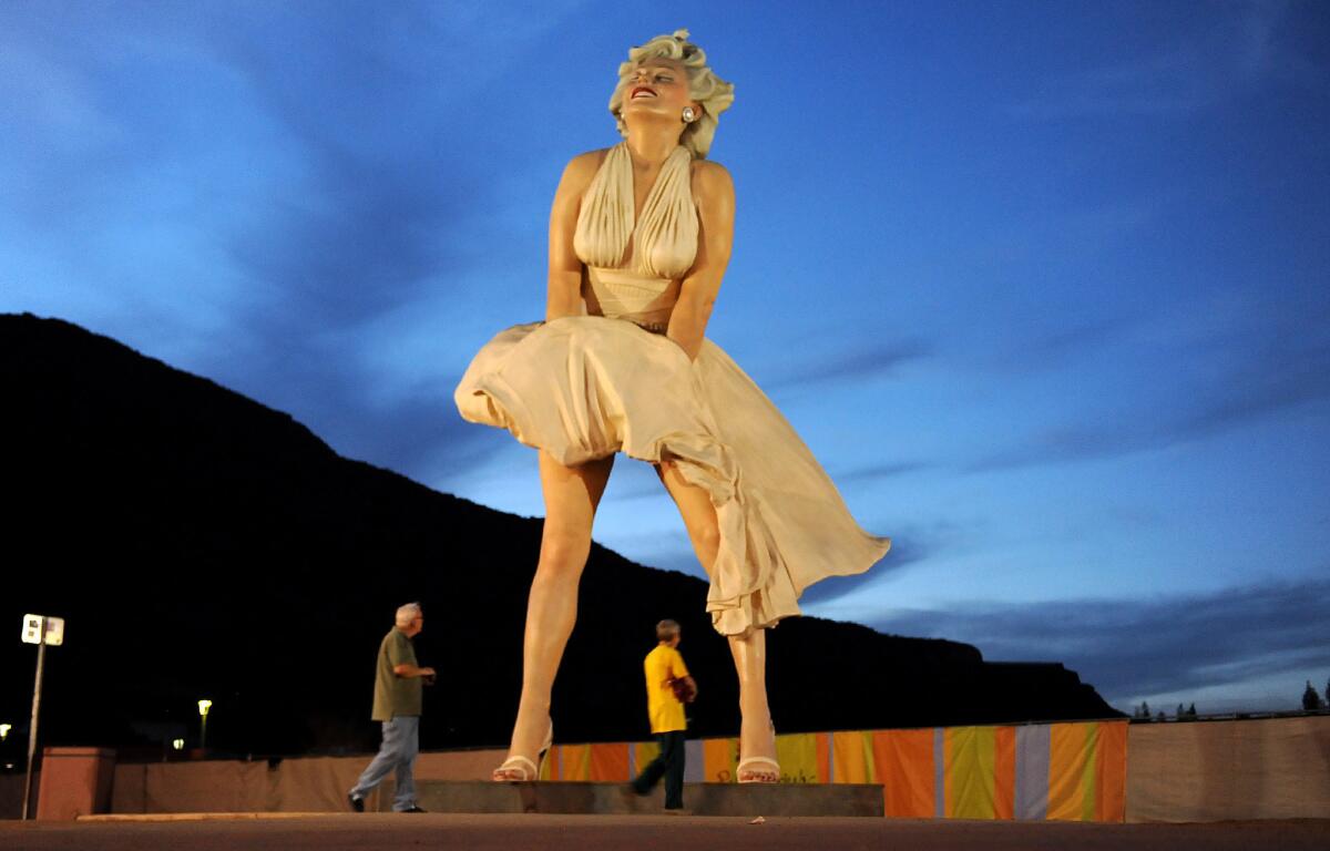 A couple walks past a 26-foot statue of Marilyn Monroe in Palm Springs.