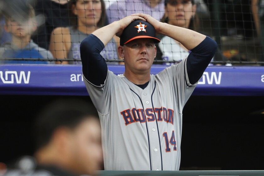 FILE - In this July 2, 2019, file photo, Houston Astros manager AJ Hinch reacts during a baseball game against the Colorado Rockies, in Denver. Houston manager AJ Hinch and general manager Jeff Luhnow were suspended for the entire season Monday, Jan. 13, 2020, and the team was fined $5 million for sign-stealing by the team in 2017 and 2018 season. Commissioner Rob Manfred announced the discipline and strongly hinted that current Boston manager Alex Cora — the Astros bench coach in 2017 — will face punishment later. Manfred said Cora developed the sign-stealing system used by the Astros. (AP Photo/David Zalubowski, File)