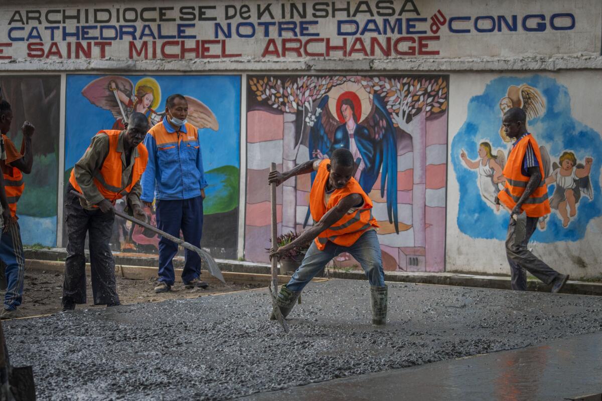 Construction workers lay concrete outside the Cathedral Notre Dame du Congo in Kinshasa, Democratic Republic of the Congo Saturday Jan. 28, 2023. Pope Francis will be in Congo and South Sudan for a six-day trip starting Jan, 31, hoping to bring comfort and encouragement to two countries that have been riven by poverty, conflicts and what he calls a "colonialist mentality" that has exploited Africa for centuries. (AP Photo/Jerome Delay)