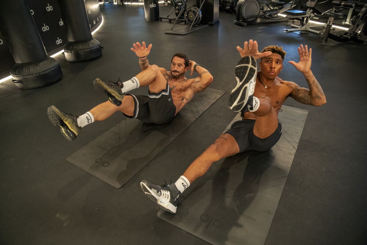 Two men doing ab workouts in a gym