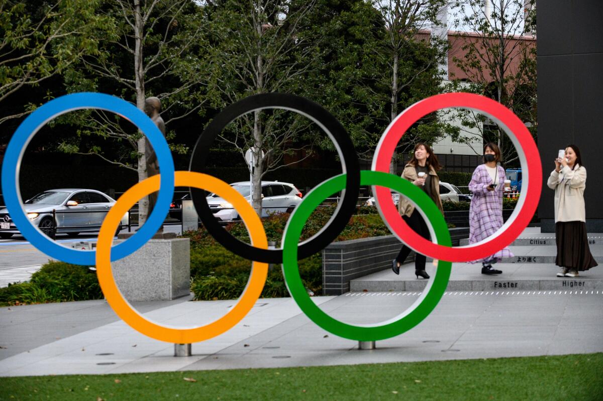 People take pictures of the Olympic Rings outside the closed Japan Olympic Museum in Tokyo on March 27, 2020, three days after the historic decision to postpone the 2020 Tokyo Olympic Games. (Photo by Philip FONG / AFP) (Photo by PHILIP FONG/AFP via Getty Images)