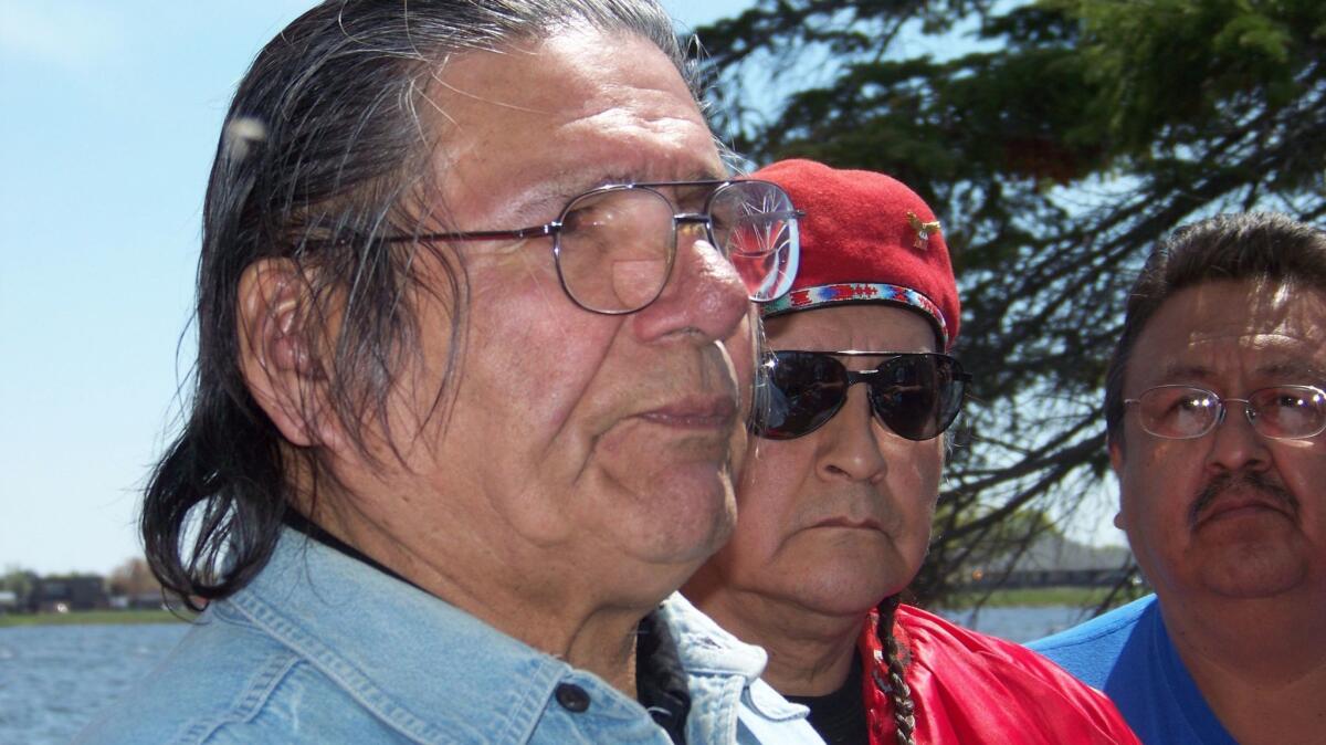 American Indian activist Dennis Banks, left, speaks to reporters on Lake Bemidji, during an American Indian treaty rights protest in Bemidji, Minn., in 2010.