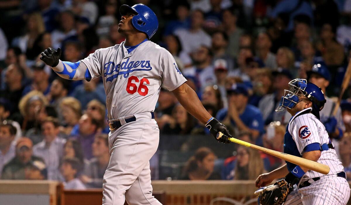 Dodgers' Yasiel Puig hits a fly ball that gets lost in the lights for a triple in the 6th inning against the Chicago Cubs on Tuesday. The Dodgers lost, 1-0, in extra innings.