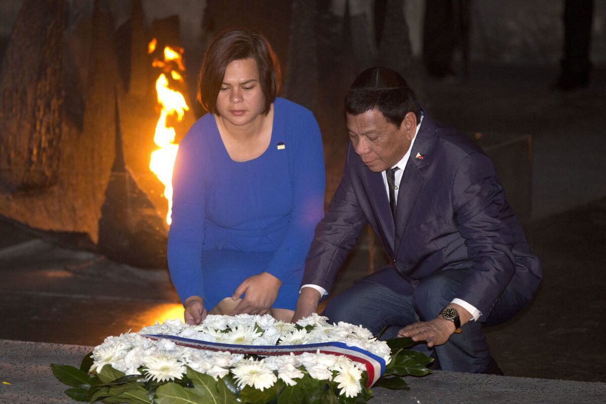FILE - Philippine President Rodrigo Duterte and his daughter Sara lay a wreath during a memorial ceremony at the Yad Vashem Holocaust Memorial in Jerusalem on Sept 3, 2018. Philippine President Rodrigo Duterte's daughter registered her candidacy Saturday, Nov. 13, 2021 for vice president in next year's elections and was adopted as the running mate of presidential candidate Ferdinand Marcos Jr., the son of the late Filipino dictator, in an alliance that immediately set off alarms among human rights activists. (AP Photo/Oded Balilty, File)
