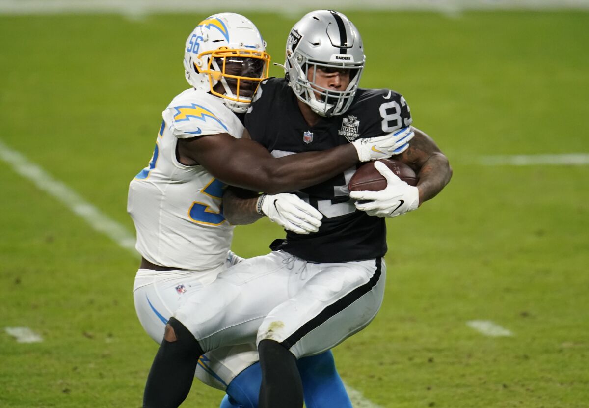 Chargers linebacker Kenneth Murray Jr. tackles Las Vegas Raiders tight end Darren Waller during a game on Dec. 13.