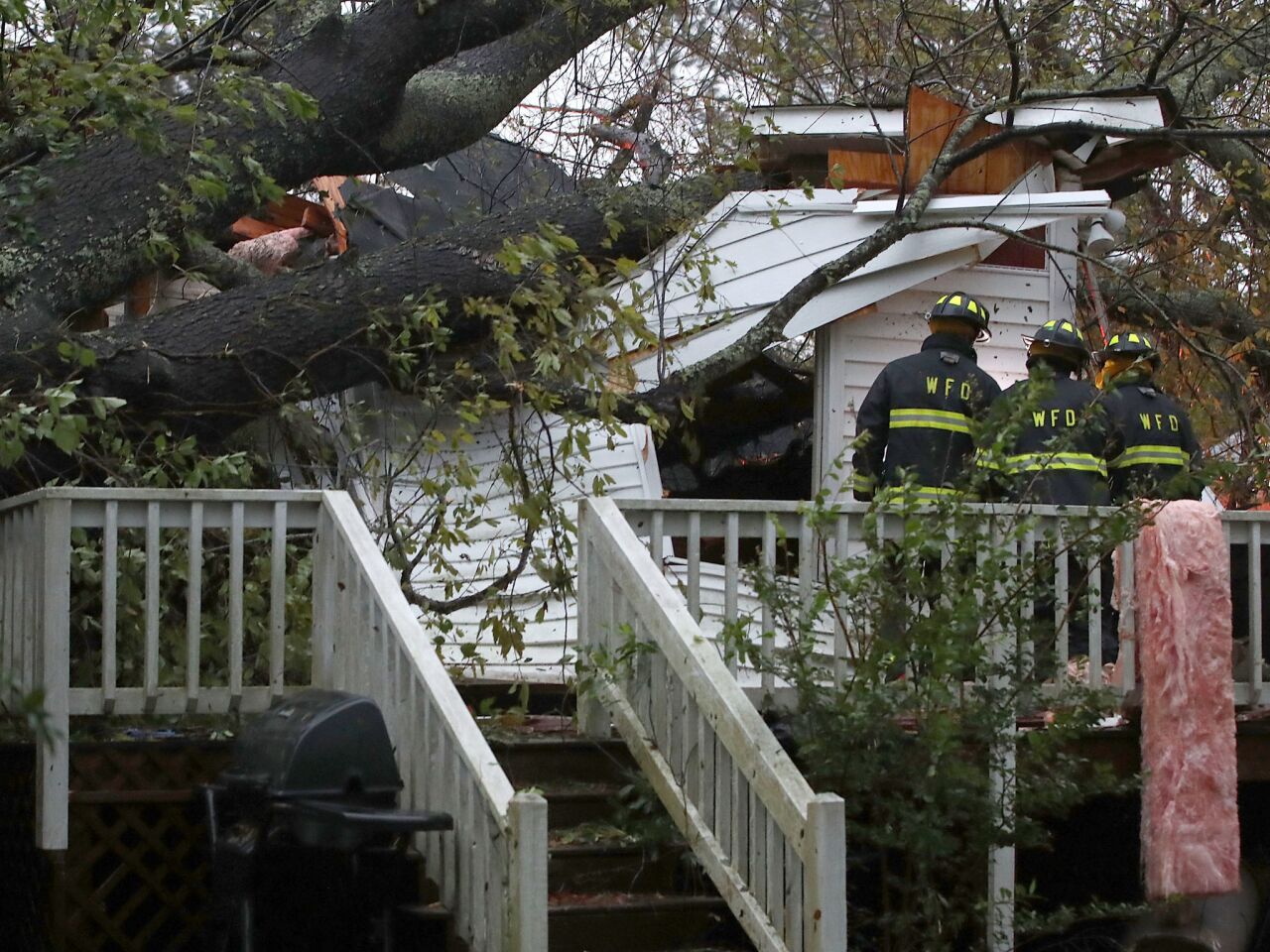 Firefighters arrive at a home where a large tree fell and trapped three people in Wilmington, N.C. One man was taken out of the home in critical condition, and the condition of the others is unknown.