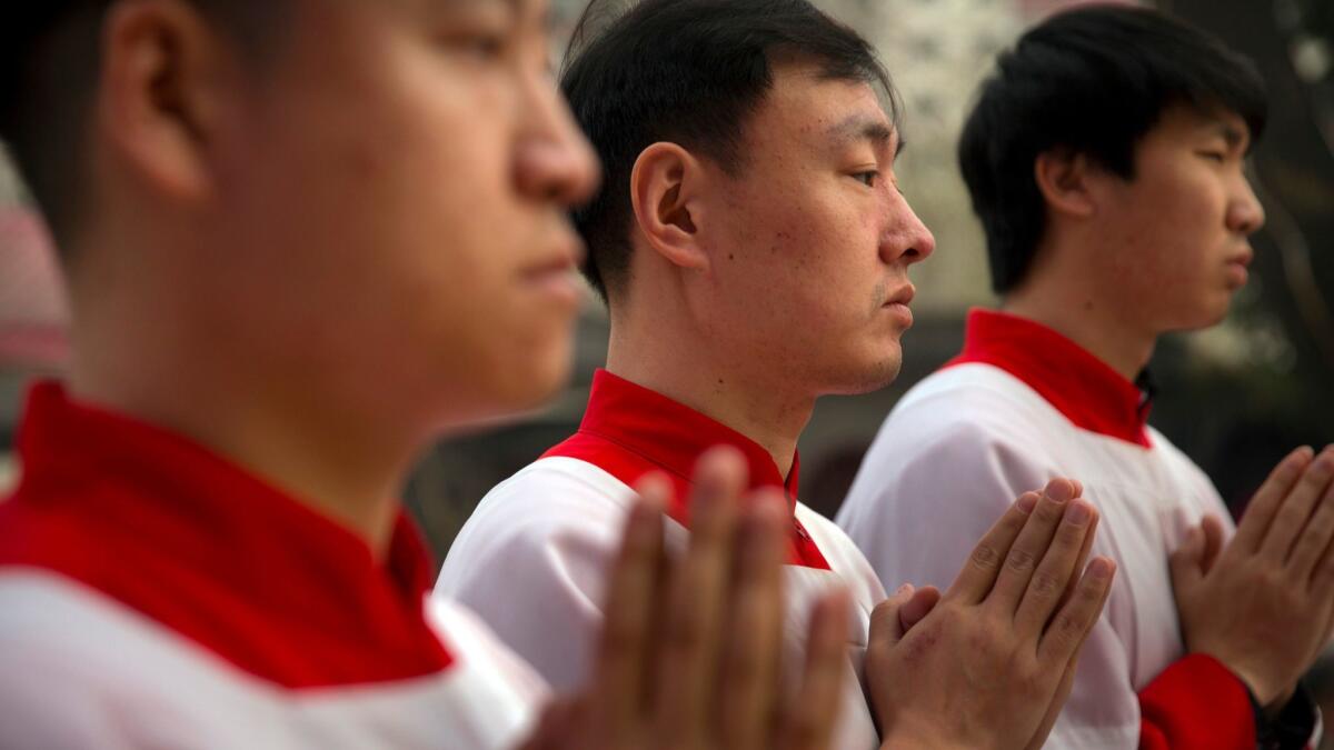 Chinese acolytes pray at the Cathedral of the Immaculate Conception, a government-sanctioned Catholic church in Beijing.