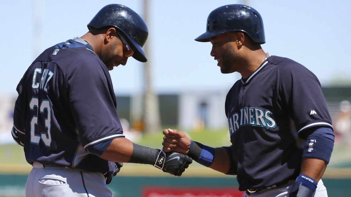 Seattle Mariners right fielder Nelson Cruz, left, celebrates with teammate Robinson Cano after hitting a two-run home run during an exhibition game against the Cleveland Indians on March 31.
