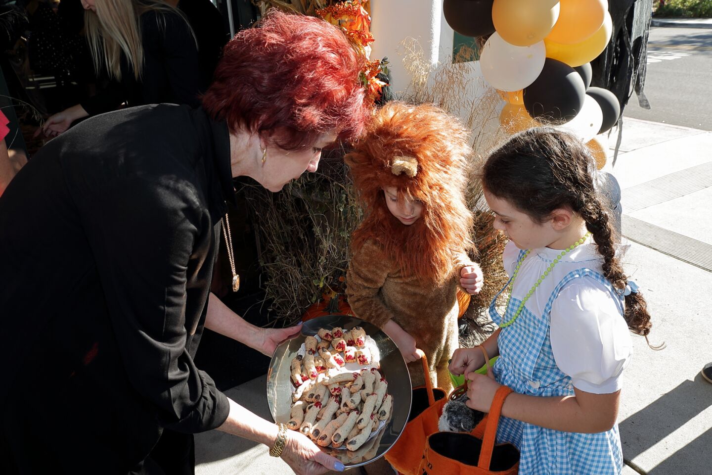Rebecca Negard of Pacific Sotheby's hands out candy to Jack and Kristen Dixon