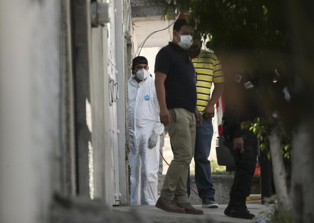 Un investigador forense permanece en la entrada de una vivienda 