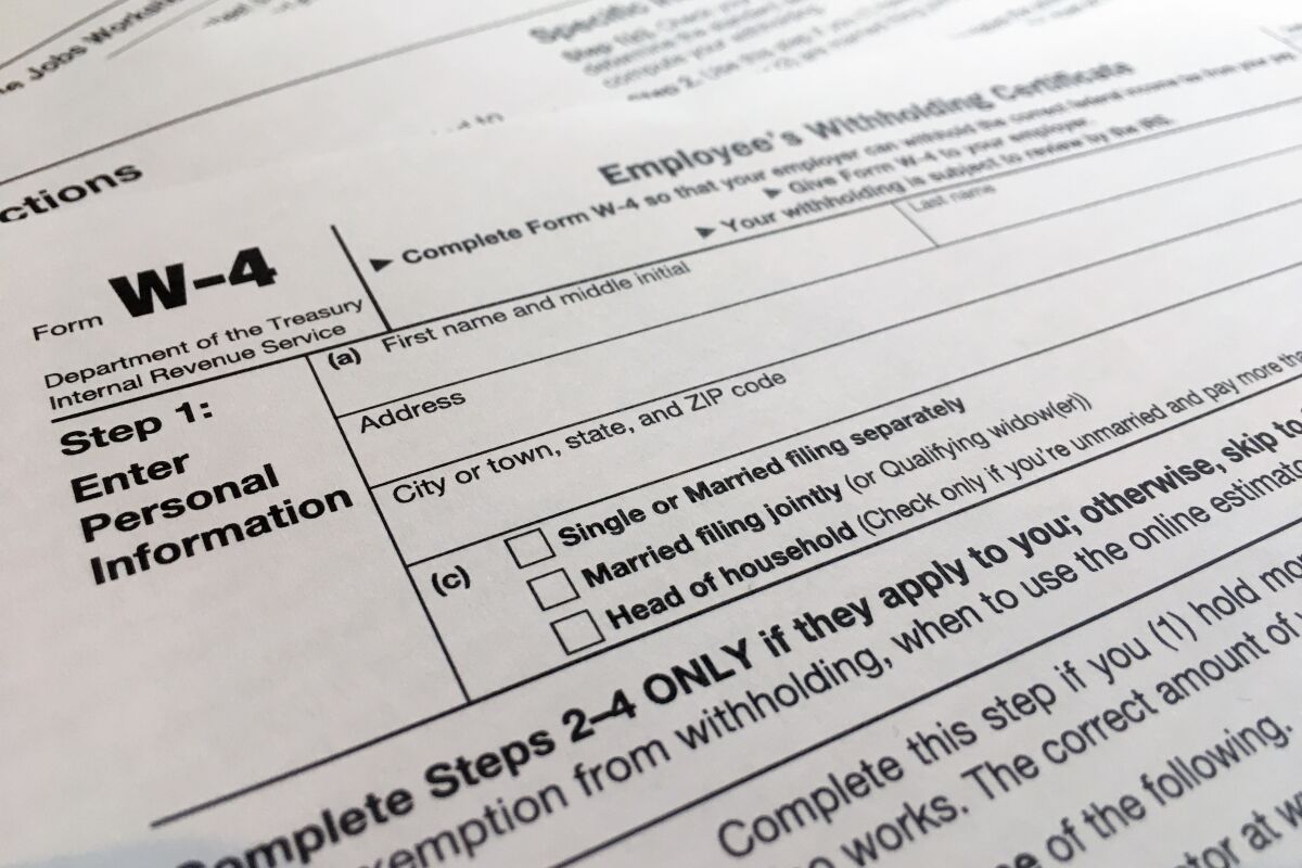 FILE - A W-4 form on Feb. 5, 2020, in New York. Monday is Tax Day, the federal deadline for individual tax filing and payments. The IRS will receive tens of millions of filings electronically and through paper forms. (AP Photo/Patrick Sison, File)