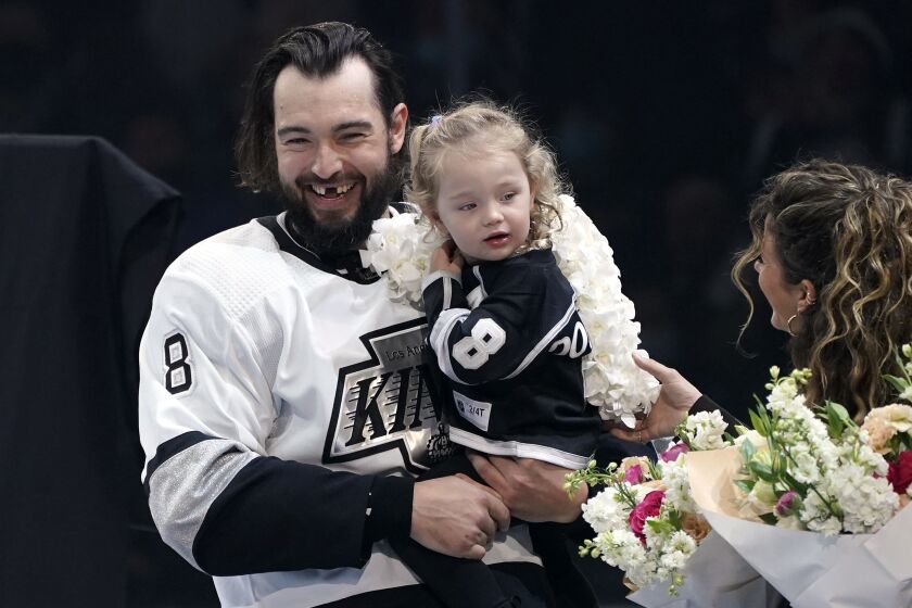 Los Angeles Kings defenseman Drew Doughty, left, stand with his daughter and wife Nicole prior to an NHL hockey game against the Edmonton Oilers Tuesday, Feb. 15, 2022, in Los Angeles as the Kings celebrated Doughty's 1,000th game played on Jan. 27th. (AP Photo/Mark J. Terrill)