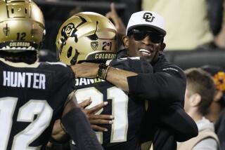 Colorado coach Deion Sanders hugs his son, safety Shilo Sanders, after he returned an interception for a touchdown