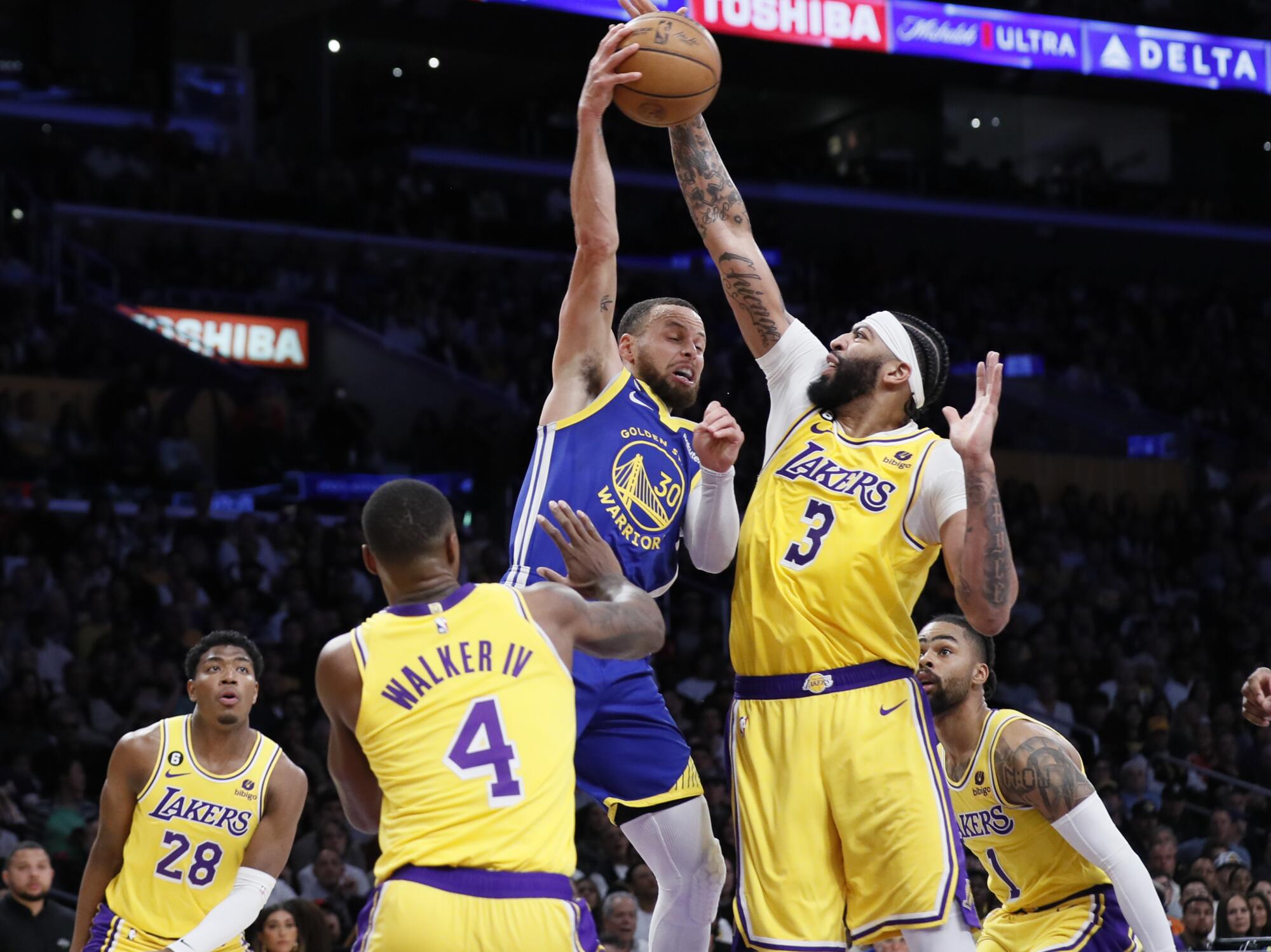 Warriors guard Stephen Curry passes over Lakers forward Anthony Davis.