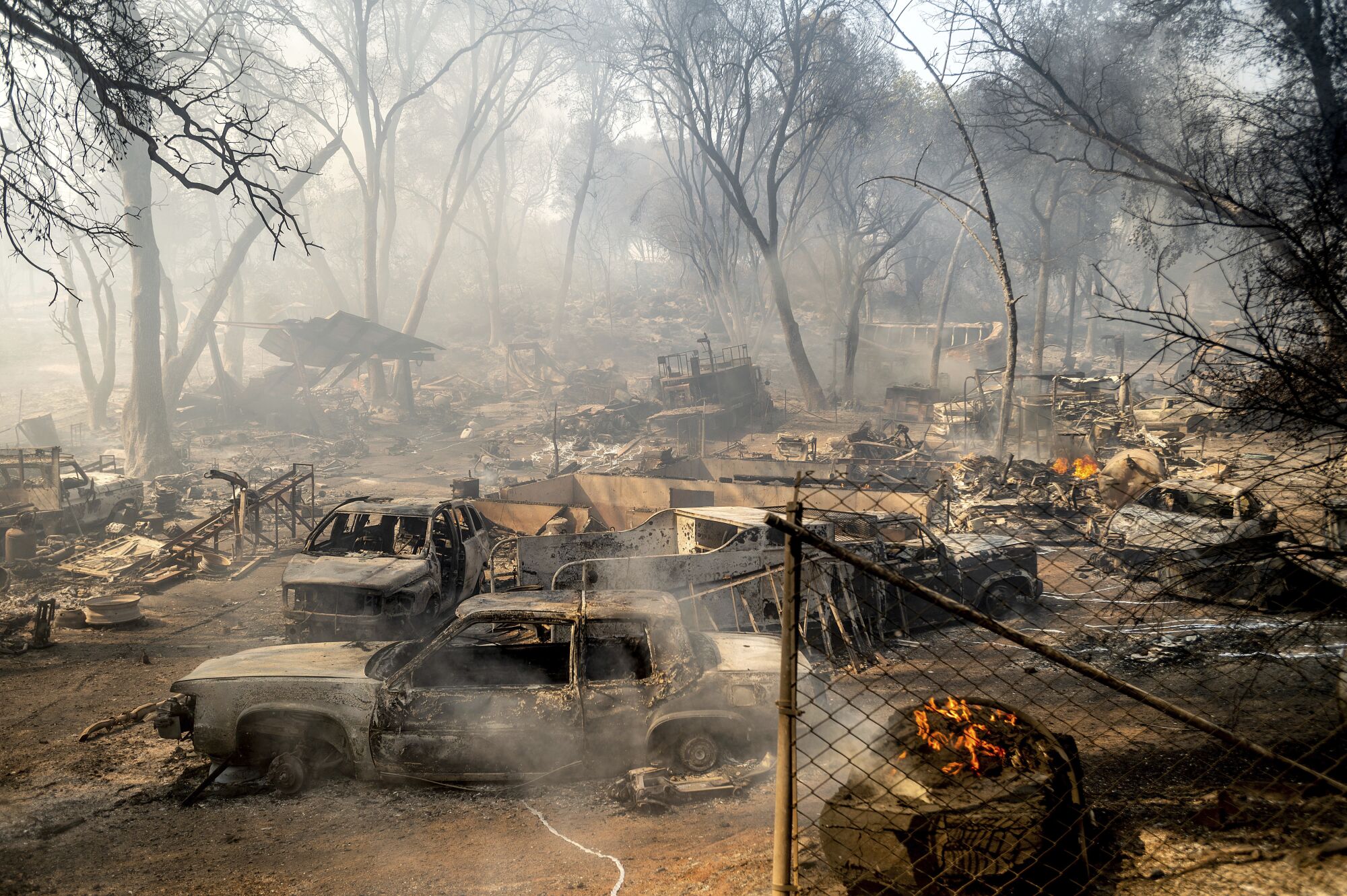 Scorched cars line a property as the Cache fire burns in Clearlake.