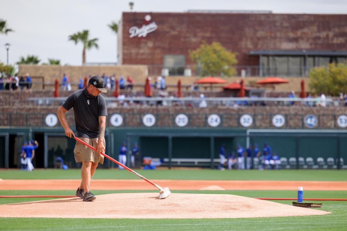 A groundsman prepares the pitchers mound before a spring training game between the Dodgers and Chicago Cubs in March.