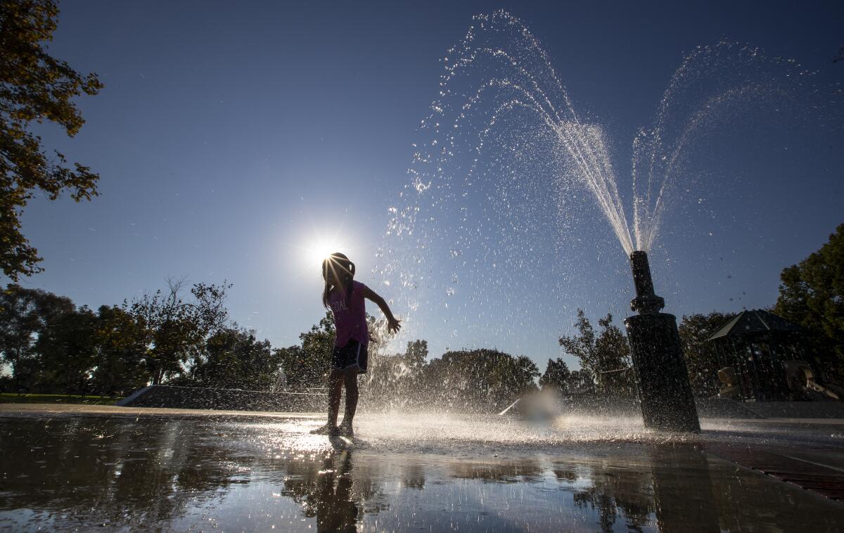 Brittany Castro, 5, of Santa Ana, plays in a splash pool at Mile Square Regional Park in Fountain Valley on Tuesday