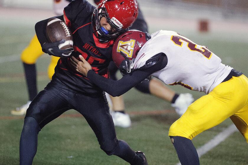 Glendale's Matthew Quiroz tries to get around the tackle by Arcadia's Steven Winnen in a Pacific League football game at Glendale High School on Thursday, October 3, 2019.