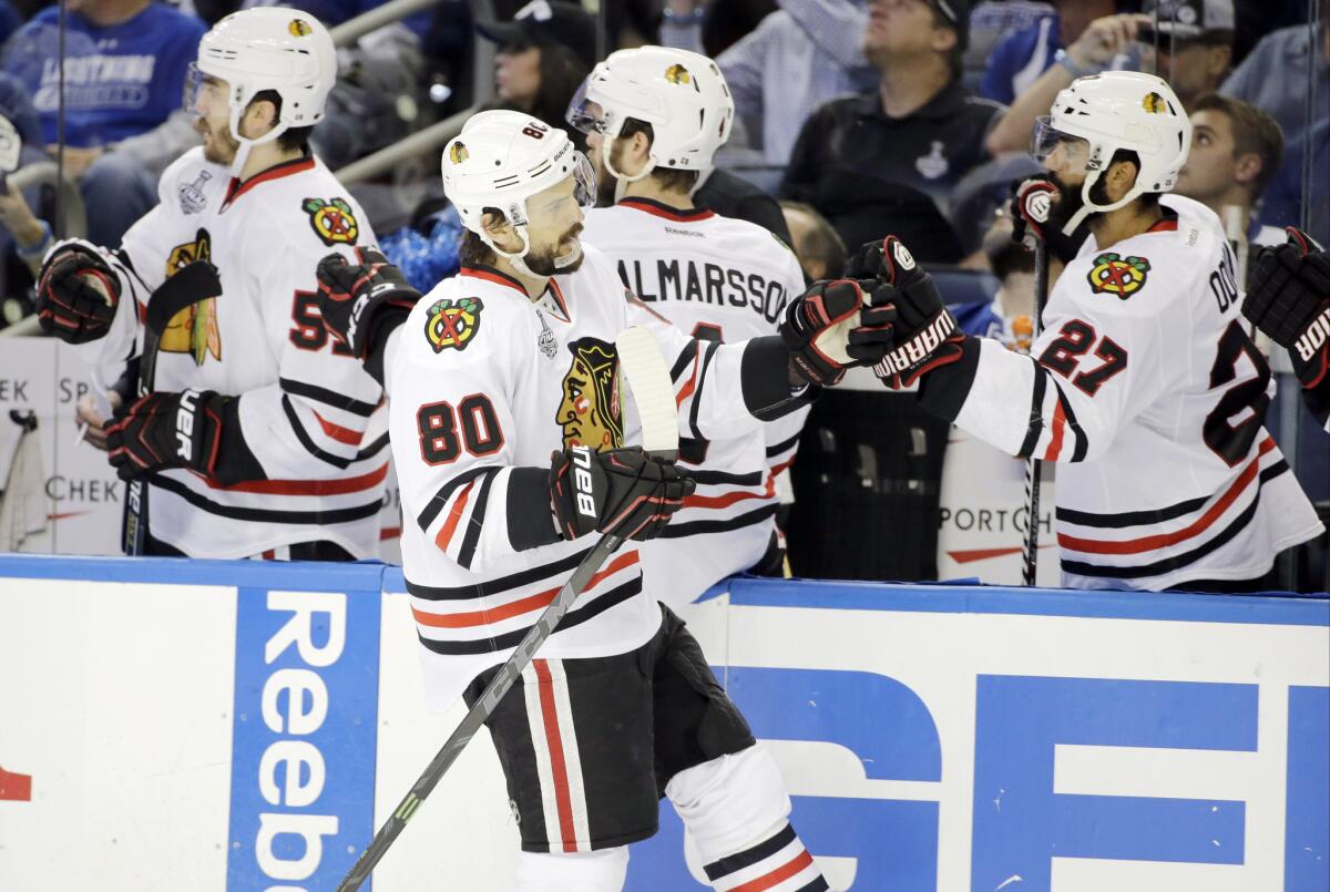 Blackhawks center Antoine Vermette (80) is congratulated by teammates after scoring a goal against the Lightning in the third period of Game 5 of the Stanley Cup Final on Saturday in Tampa.
