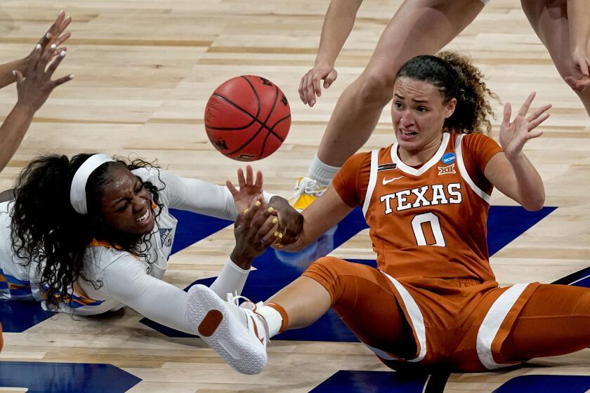 Texas guard Celeste Taylor (0) and UCLA forward Michaela Onyenwere (21) chase a loose ball during the first half of a college basketball game in the second round of the women's NCAA tournament at the Alamodome in San Antonio, Wednesday, March 24, 2021. (AP Photo/Charlie Riedel)