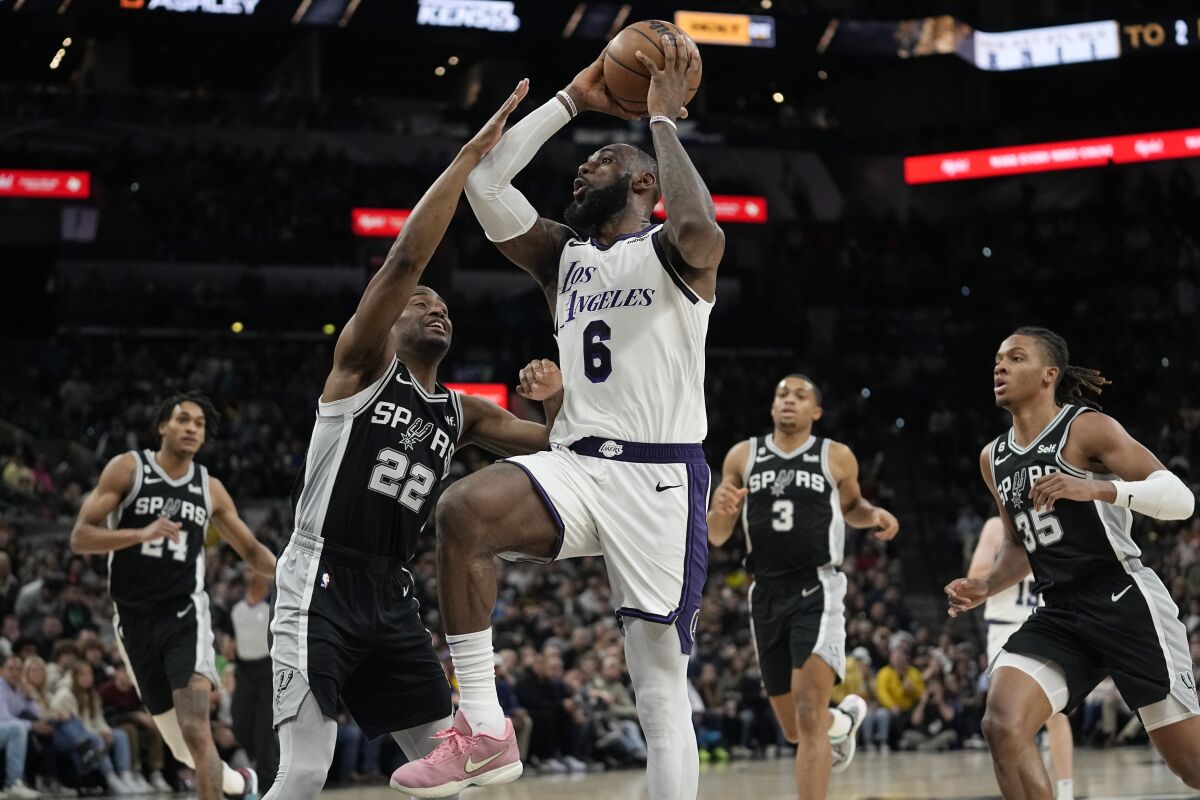 Lakers forward LeBron James drives to the basket against Spurs guard Malaki Branham.