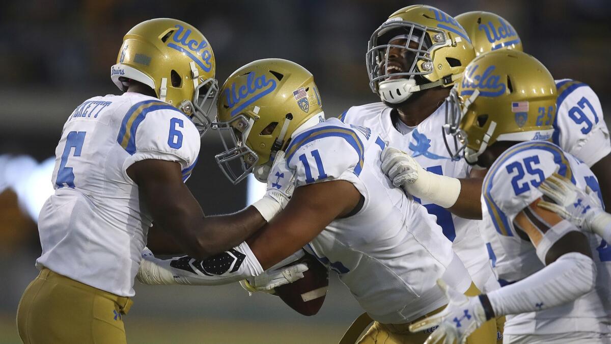 UCLA's Keisean Lucier-South (11) celebrates with Adarius Pickett (6) after intercepting a pass against California in the second half.