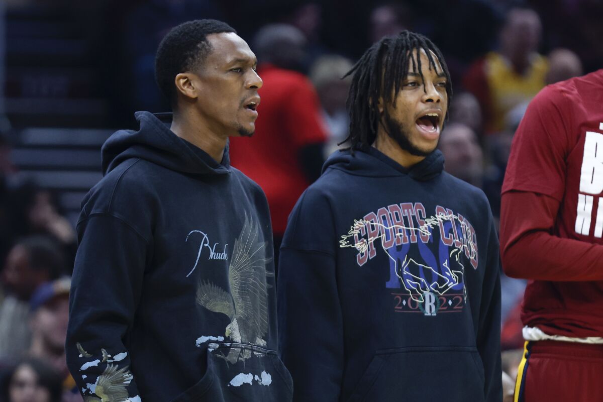 Injured Cleveland Cavaliers guards Rajon Rondo, left, and Darius Garland cheer for teammates during the first half of the team's NBA basketball game against the Minnesota Timberwolves, Monday, Feb. 28, 2022, in Cleveland. (AP Photo/Ron Schwane)