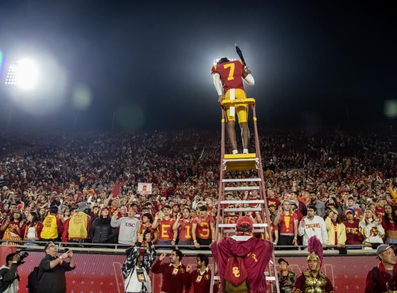 Calen Bullock celebrates with fans atop the USC band director stand following the Trojans' win over Notre Dame in November 2022.