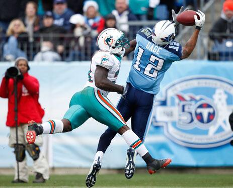 Justin Gage of the Tennessee Titans catches a touchdown pass in the first half behind Vontae Davis of the Miami Dolphins at LP Field on December 20 in Nashville, Tennessee.