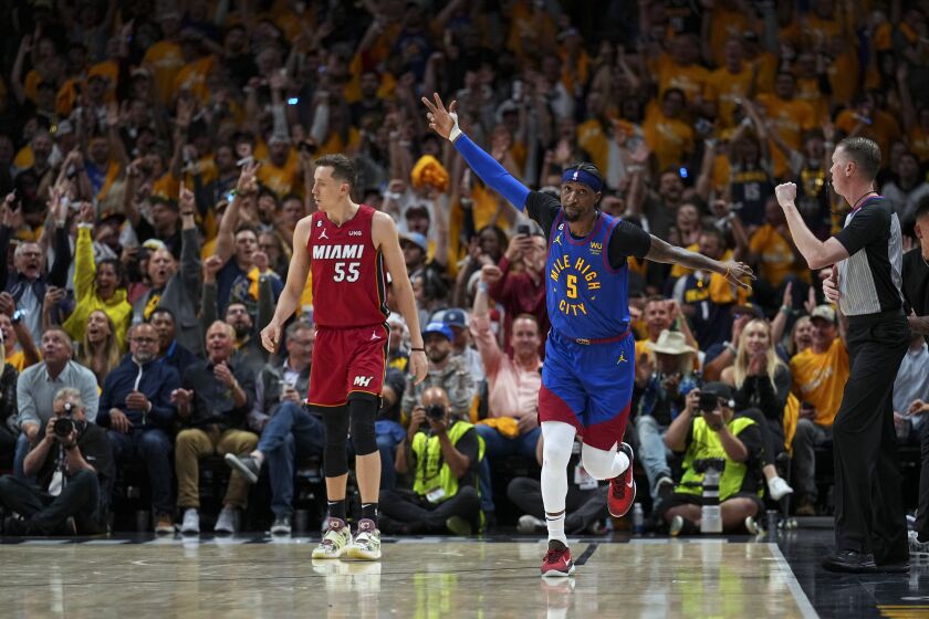 Denver Nuggets guard Kentavious Caldwell-Pope, right, reacts after making a 3-poiunt basket against the Miami Heat during the second half of Game 1 of basketball's NBA Finals, Thursday, June 1, 2023, in Denver. (AP Photo/Jack Dempsey)