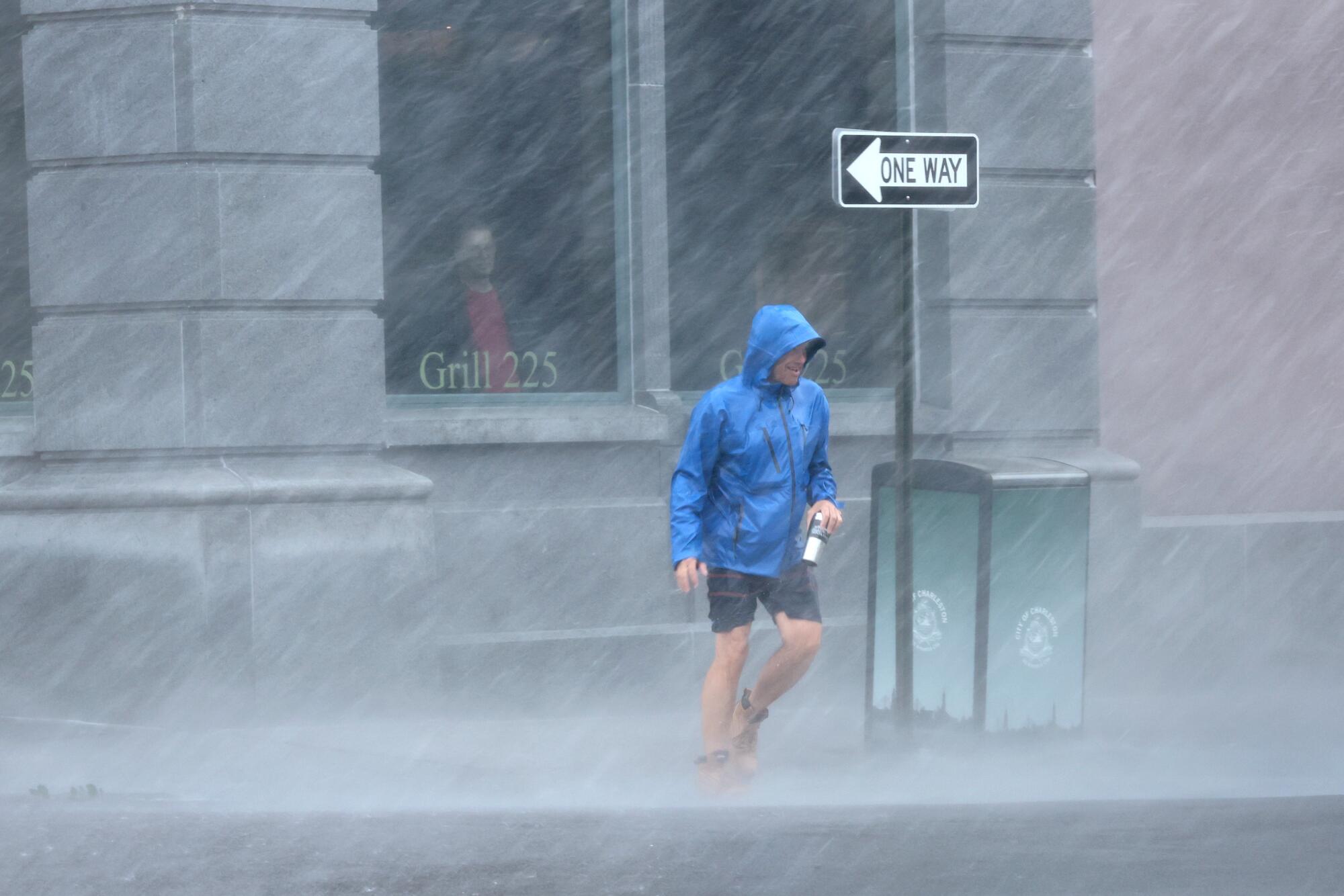 A pedestrian navigates driving rain Friday in Charleston, S.C.