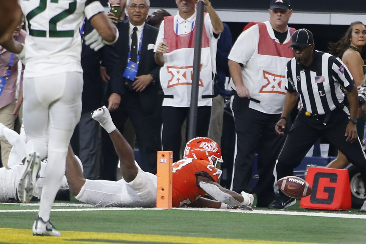 Oklahoma State running back Dezmon Jackson (27) is stopped short of the goal line by Baylor safety Jairon McVea on fourth down in the second half of an NCAA college football game for the Big 12 Conference championship in Arlington, Texas, Saturday, Dec. 4, 2021. (AP Photo/Tim Heitman)