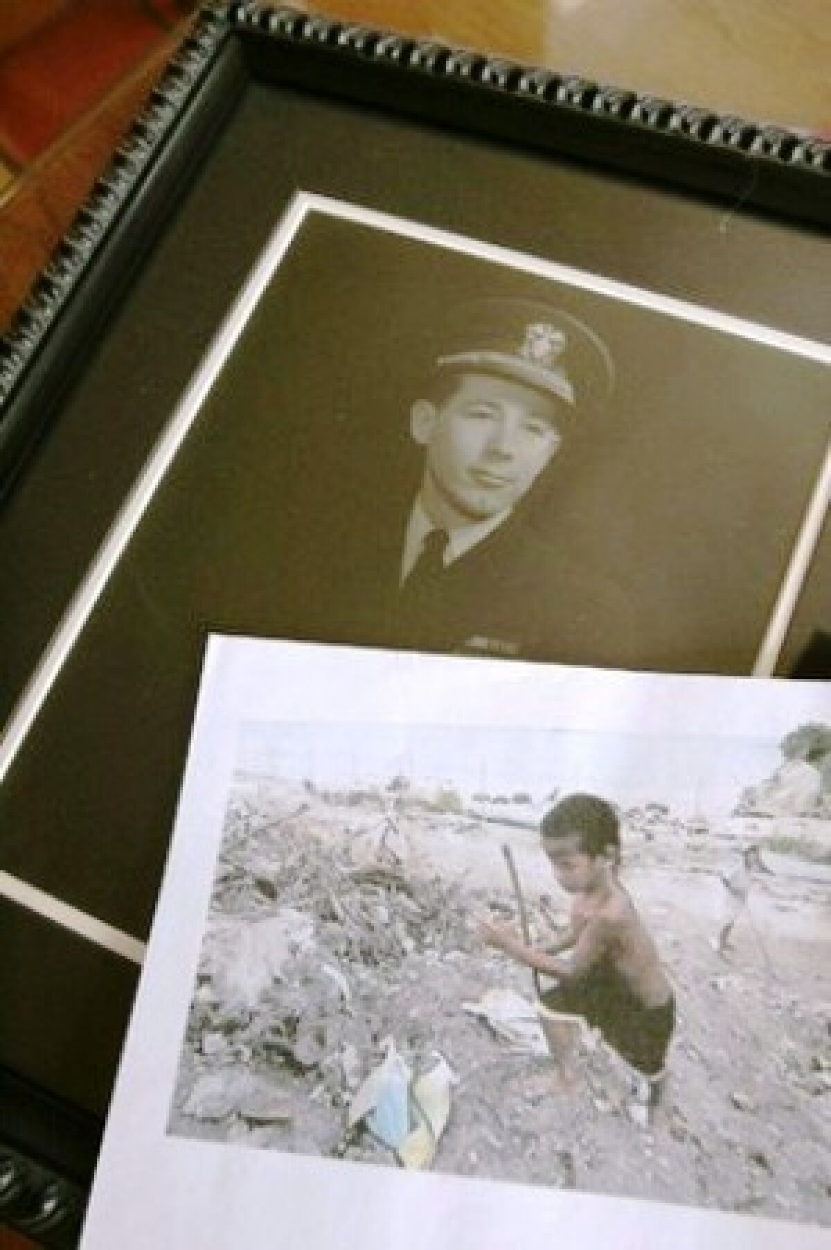 Photos show Leon Cooper in his Navy uniform and a child playing in the trash on Tarawa.