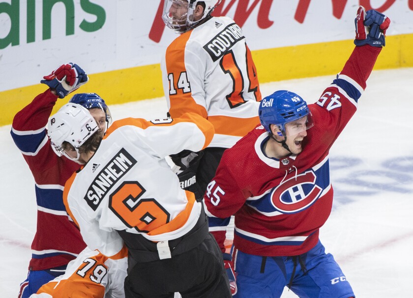 Montreal Canadiens' Laurent Dauphin (45) scores against Philadelphia Flyers goaltender Carter Hart (79) as Flyers' Travis Sanheim (6) defends during a third period NHL hockey game in Montreal, Thursday, Dec. 16, 2021. (Graham Hughes/The Canadian Press via AP)