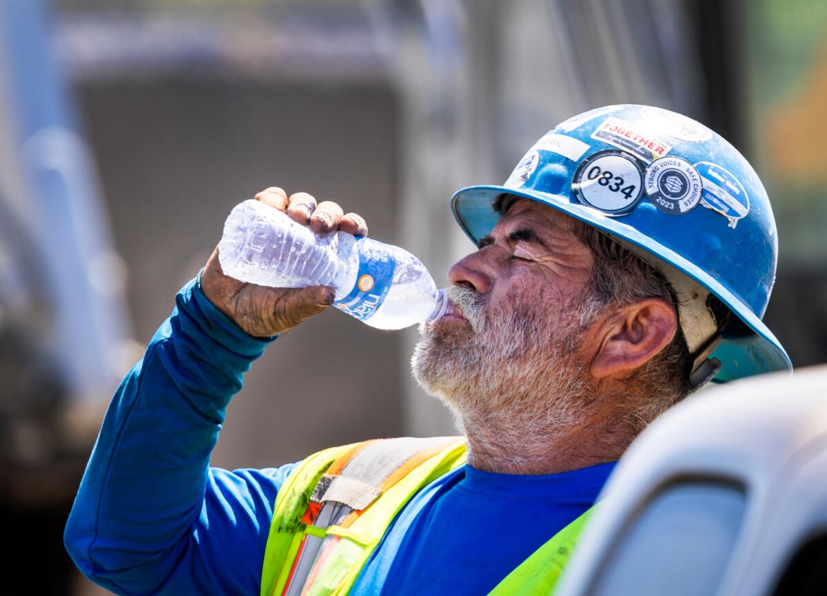 A construction worker takes a water break.