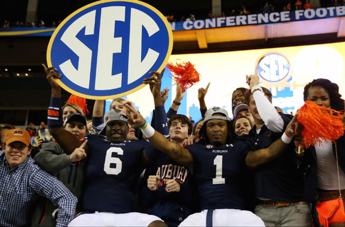 Auburn's Jeremy Johnson (6) and Trovon Reed (1) celebrate with fans after winning the SEC title over Missouri on Saturday night at the Georgia Dome.
