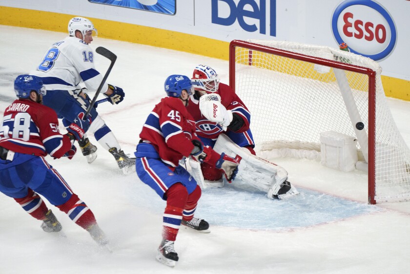 Tampa Bay Lightning's Ondrej Palat scores past Montreal Canadiens goaltender Jake Allen as Canadiens' David Savard, left, and Laurent Dauphin watch during the third period of an NHL hockey game Tuesday, Dec. 7, 2021, in Montreal. (Paul Chiasson/The Canadian Press via AP)