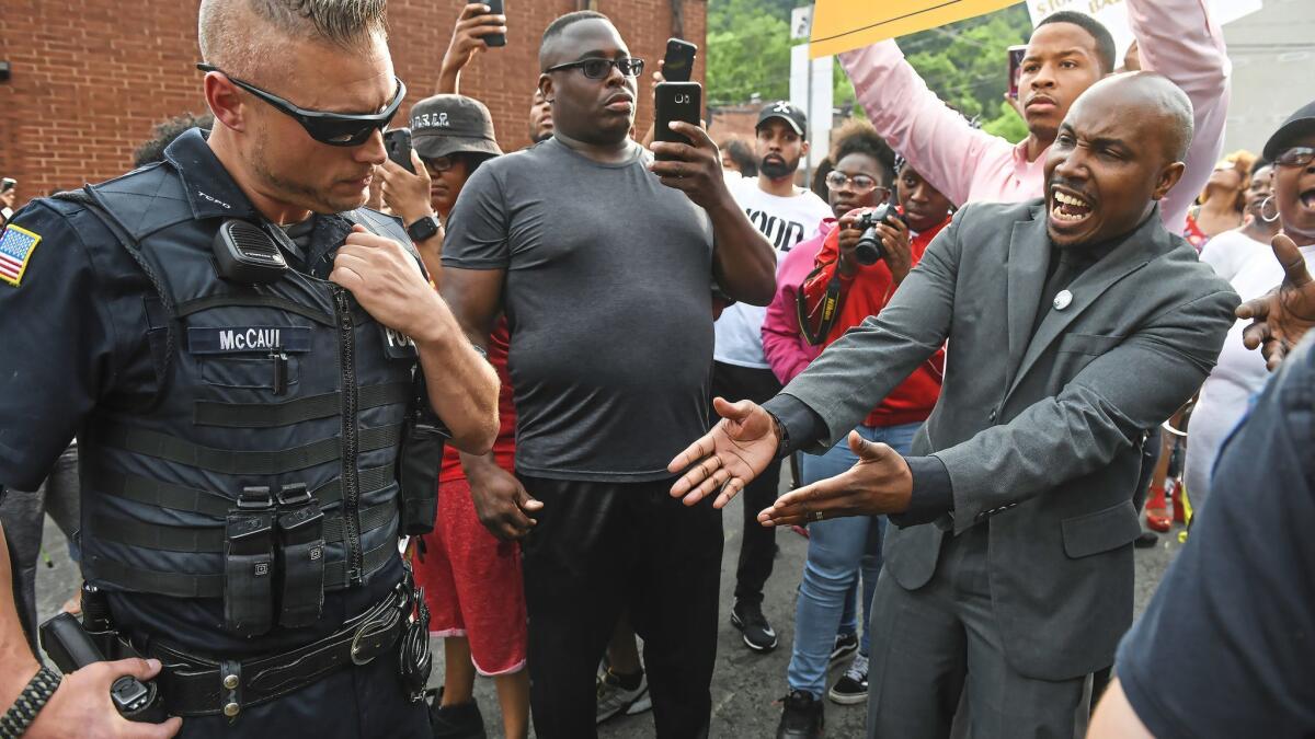 Leonard Hammonds II of Penn Hills, right, points out that a Turtle Creek Police officer has his had on his weapon during a rally June 20 in East Pittsburgh.