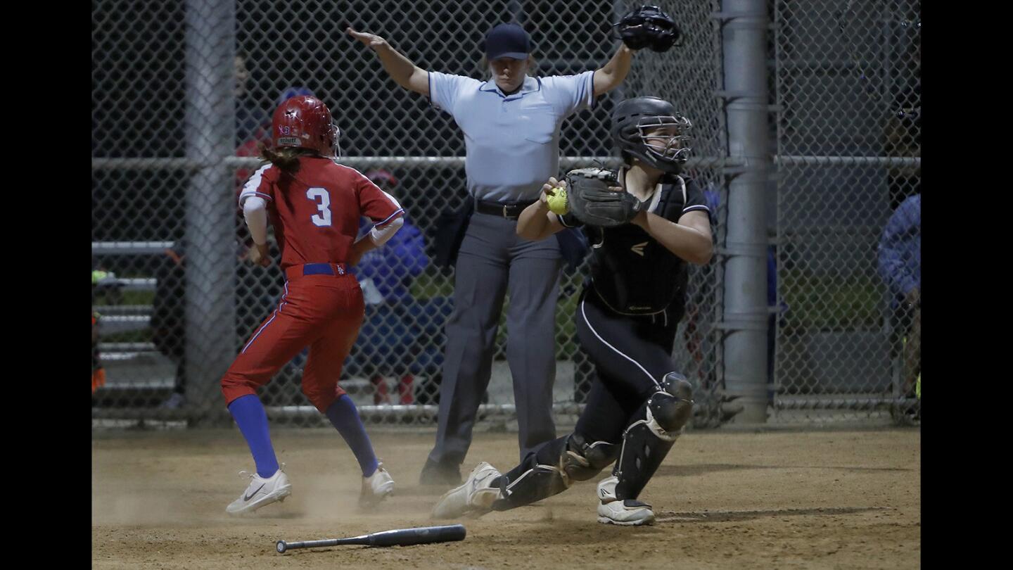 Los Alamitos High's Erin Mendoza (3) scores the winning run against Huntington Beach catcher Reanna Rudd during the seventh inning in a Sunset League game on Tuesday, April 17.