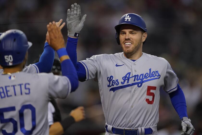 Los Angeles Dodgers' Freddie Freeman high fives teammates after hitting a three-run home run against the Arizona Diamondbacks during the second inning of a baseball game, Thursday, May 26, 2022, in Phoenix. (AP Photo/Matt York)