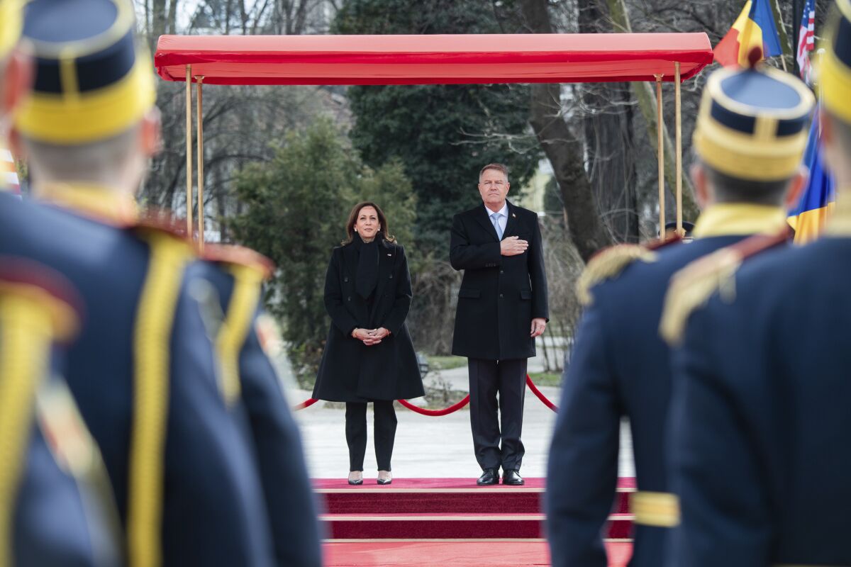 Romanian President Klaus Iohannis and U.S. Vice President Kamala Harris stand next to each other