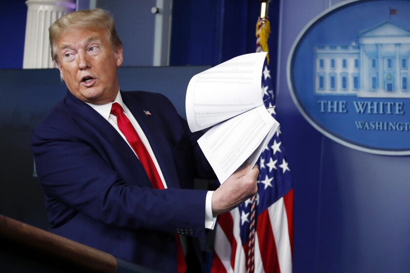 FILE - President Donald Trump holds up papers as he speaks about the coronavirus in the James Brady Press Briefing Room of the White House, April 20, 2020, in Washington. As president, Donald Trump never liked to leave a paper trail. He avoided email, admonished aides to stop taking notes during meetings and ripped up documents when he finished with them. But Trump was unwilling to part with some of his administration's records when he left the White House last year, whisking them away to Mar-a-Lago, his Florida resort. (AP Photo/Alex Brandon, File)