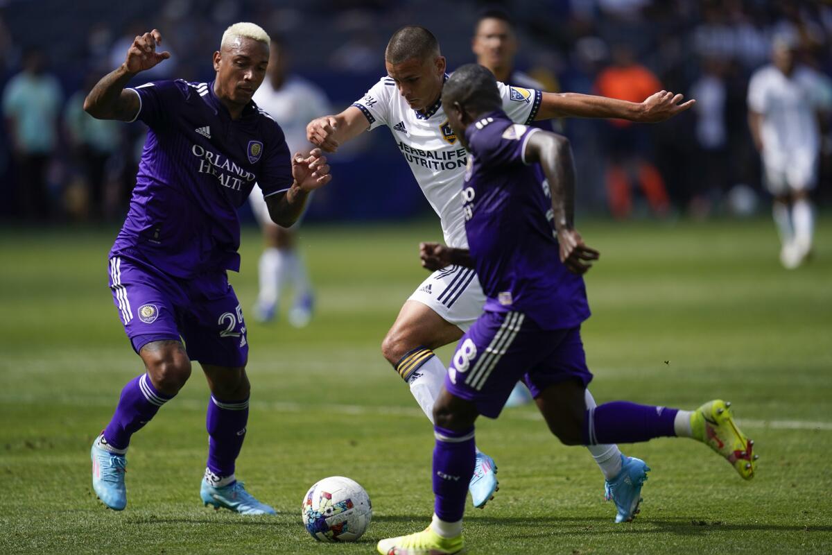 Orlando City's Antônio Carlos, left, and Jhegson Sebastian Mendez defend against Dejan Joveljić.