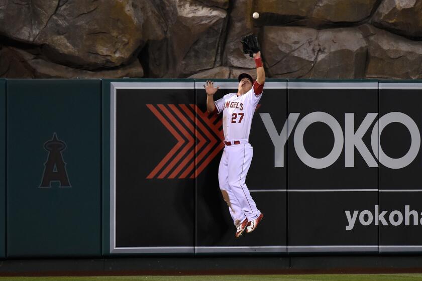Angels center fielder Mike Trout leaps to rob Colorado shortstop Troy Tulowitzki of a home run in the 10th inning on May 13 in Anaheim.