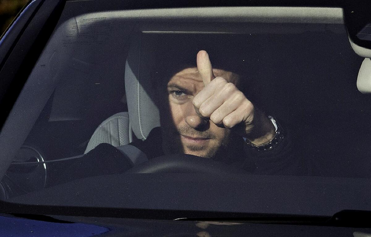 Liverpool's Steven Gerrard gives a thumbs-up to photographers as he drives away from the team's Melwood training facility Friday after announcing his intention to leave the squad after this season.
