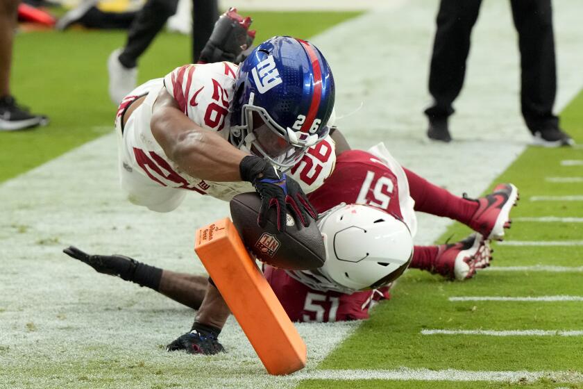 New York Giants running back Saquon Barkley (26) dives into the end zone for a touchdown as Arizona Cardinals linebacker Krys Barnes (51) defends during the second half of an NFL football game, Sunday, Sept. 17, 2023, in Glendale, Ariz. (AP Photo/Rick Scuteri)