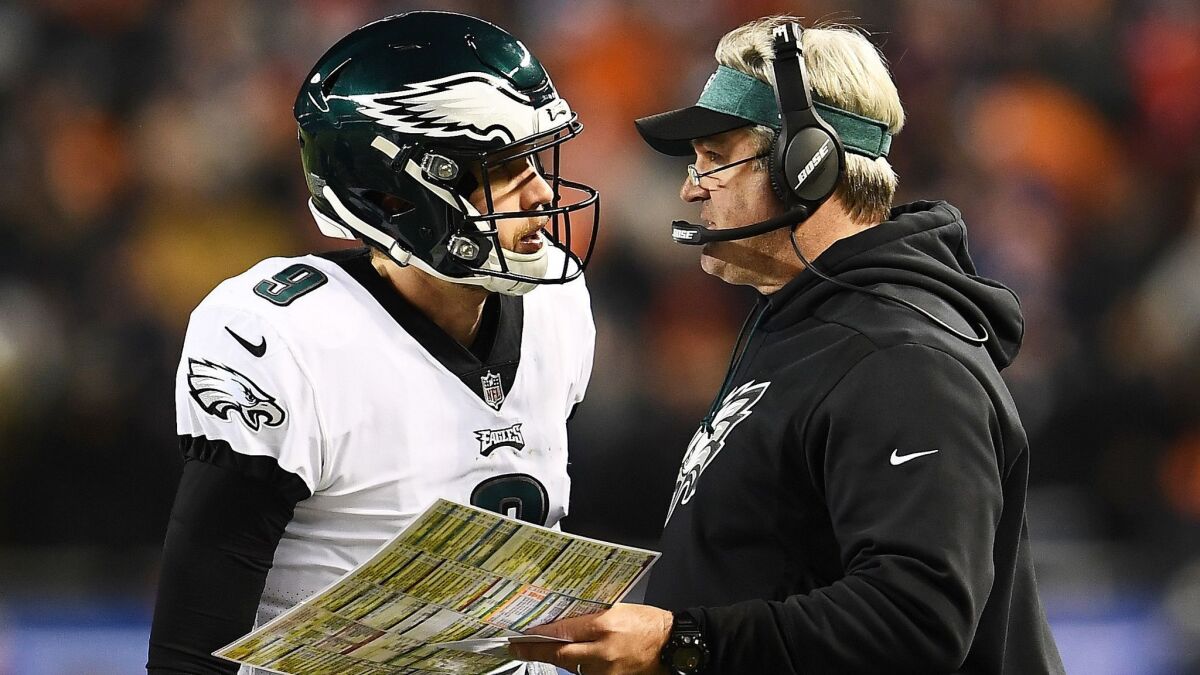 Eagles quarterback Nick Foles talks to coach Doug Pederson during the fourth quarter of an NFC wild-card game against the Bears last weekend.